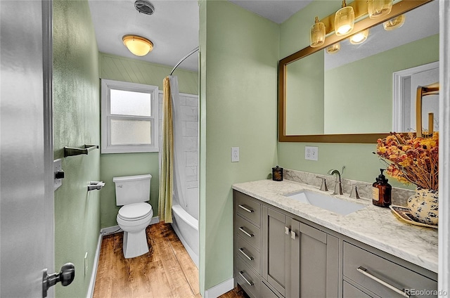 bathroom featuring wood finished floors, vanity, toilet, and shower / bathtub combination with curtain