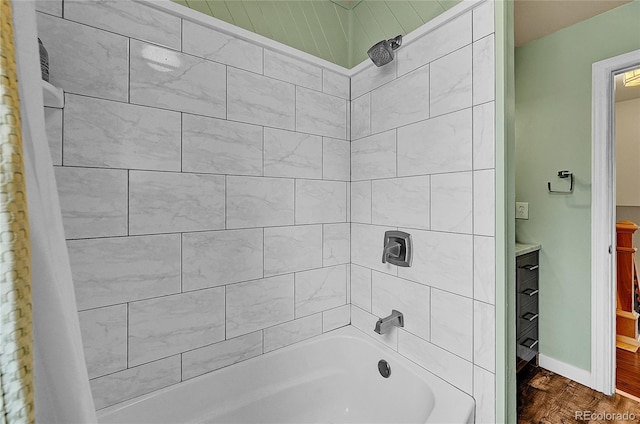 bathroom with shower / washtub combination, baseboards, and wood finished floors
