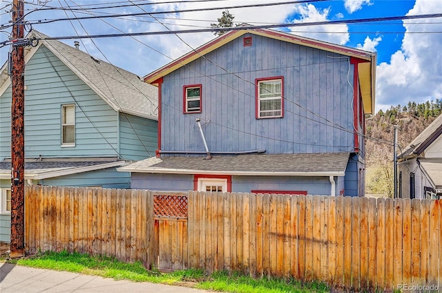view of front of house with fence and roof with shingles