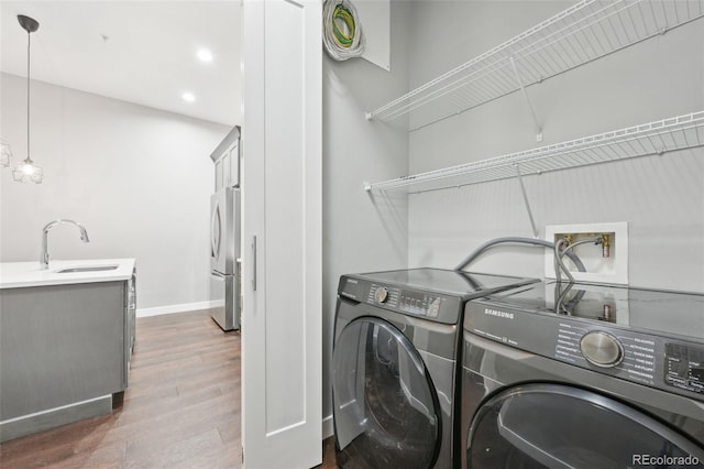 laundry room with dark wood-type flooring, independent washer and dryer, and sink