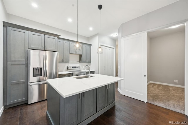 kitchen with pendant lighting, sink, gray cabinetry, stainless steel appliances, and an island with sink