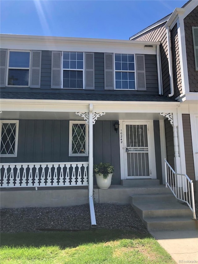 property entrance with covered porch and board and batten siding