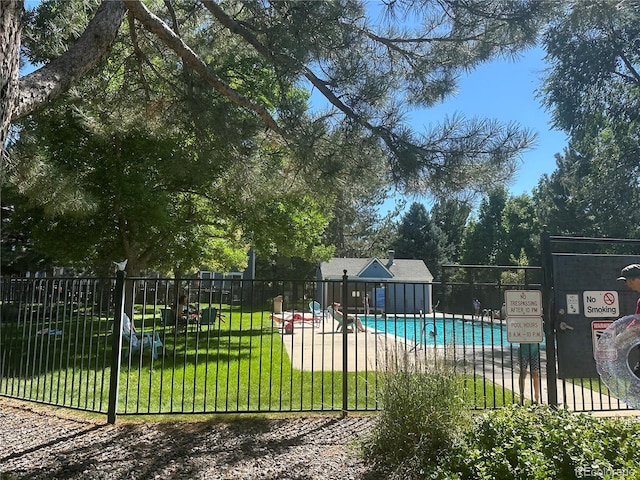 pool featuring a lawn and fence