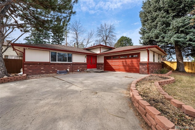 ranch-style house with brick siding, driveway, an attached garage, and fence