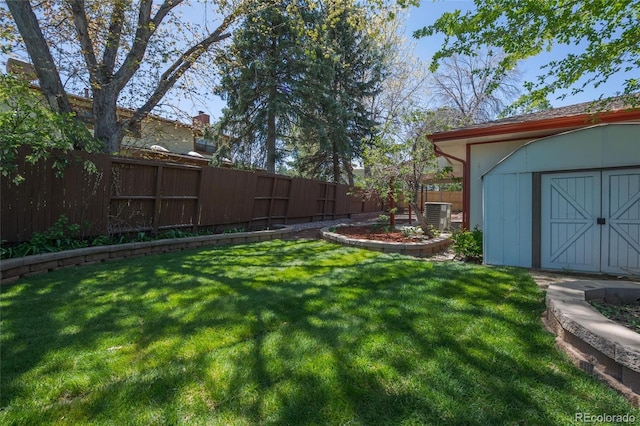 view of yard featuring an outdoor structure, a fenced backyard, and a storage unit