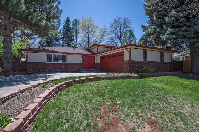 view of front facade with driveway, brick siding, fence, an attached garage, and a front lawn