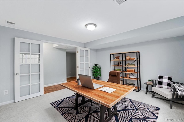 office with baseboards, light carpet, and visible vents
