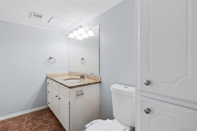 bathroom with toilet, visible vents, vanity, and crown molding