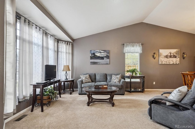 carpeted living room with baseboards, visible vents, plenty of natural light, and lofted ceiling