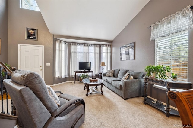 living area with plenty of natural light, light carpet, and high vaulted ceiling