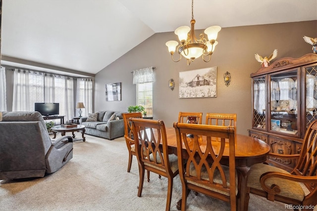 dining area featuring an inviting chandelier, light carpet, and lofted ceiling