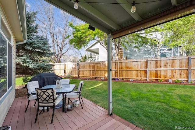 deck featuring a yard, outdoor dining area, and a fenced backyard