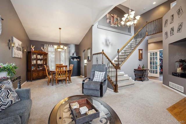 living area featuring visible vents, stairway, high vaulted ceiling, a notable chandelier, and carpet