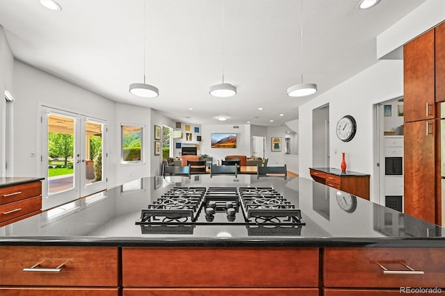kitchen featuring recessed lighting, open floor plan, black gas cooktop, a center island, and dark stone counters