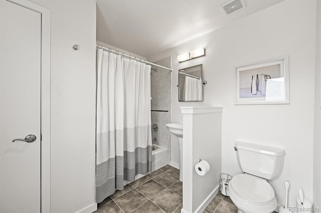 bathroom featuring toilet, shower / bath combo, baseboards, and tile patterned flooring