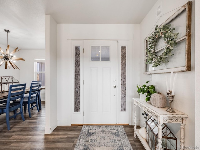 entrance foyer featuring an inviting chandelier and dark wood-type flooring