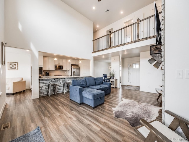 living room with a high ceiling and hardwood / wood-style flooring