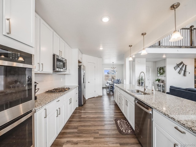 kitchen with white cabinets, appliances with stainless steel finishes, hanging light fixtures, and sink