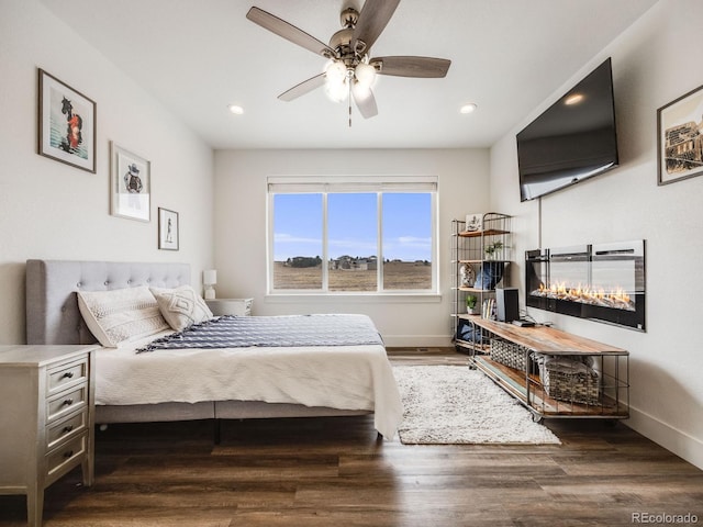 bedroom with dark hardwood / wood-style floors and ceiling fan