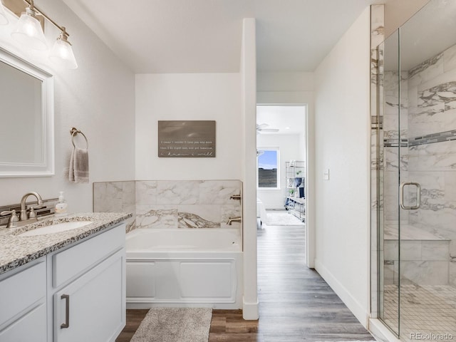 bathroom with hardwood / wood-style flooring, vanity, separate shower and tub, and ceiling fan