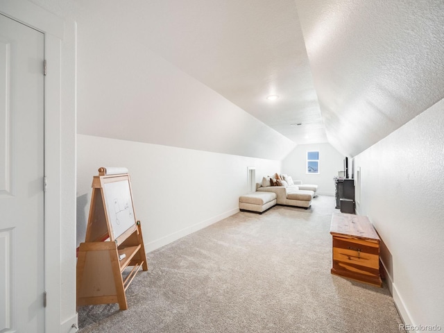 interior space featuring a textured ceiling, carpet floors, and lofted ceiling