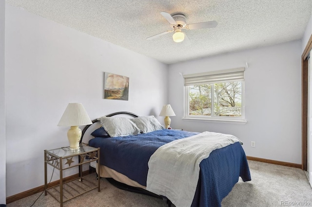carpeted bedroom featuring baseboards, a textured ceiling, and ceiling fan