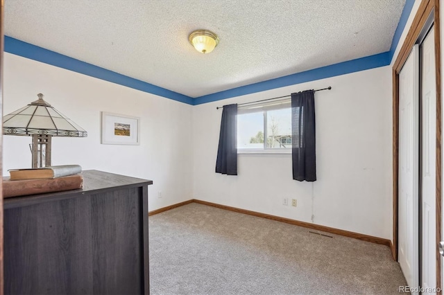 bedroom featuring a textured ceiling, a closet, baseboards, carpet flooring, and visible vents