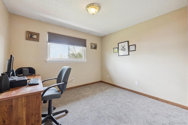 office area featuring baseboards, carpet flooring, and a textured ceiling