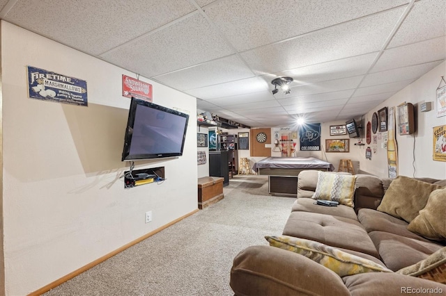 living area with baseboards, carpet flooring, and a paneled ceiling