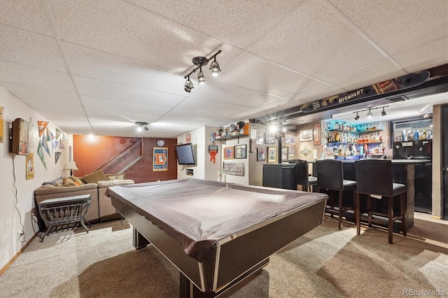 playroom with a paneled ceiling, rail lighting, and a dry bar