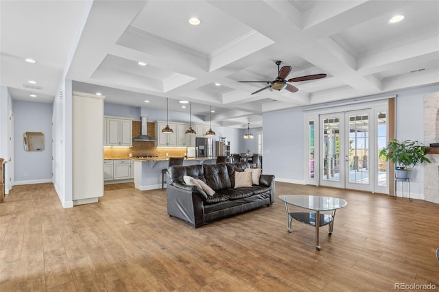 living room with ceiling fan, coffered ceiling, light hardwood / wood-style floors, french doors, and beamed ceiling