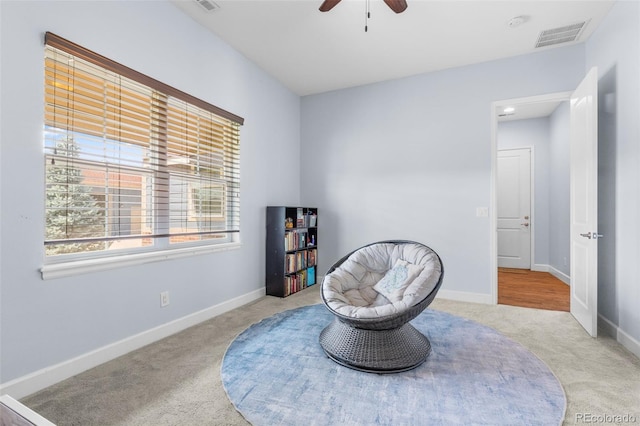 living area featuring ceiling fan and light colored carpet