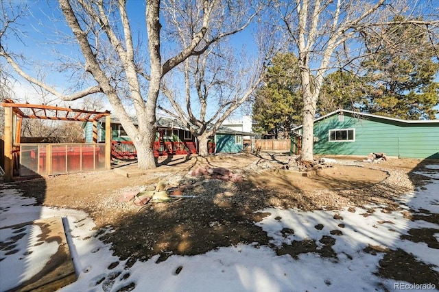 yard covered in snow featuring a pergola