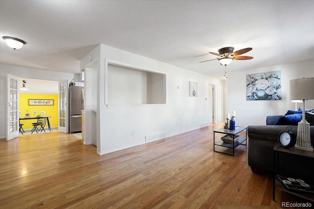 living room with ceiling fan and wood-type flooring