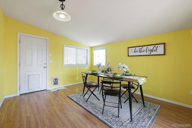 dining area featuring lofted ceiling and hardwood / wood-style floors