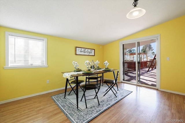 dining area featuring lofted ceiling and hardwood / wood-style floors