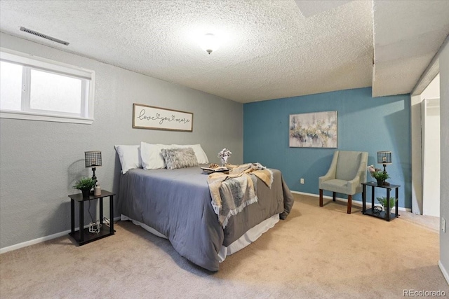 bedroom with light carpet and a textured ceiling