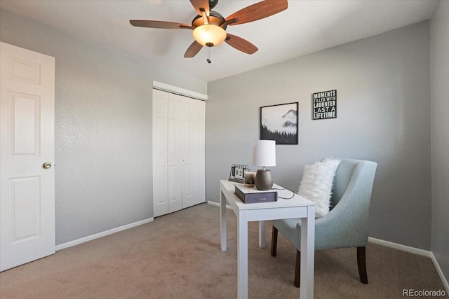 carpeted home office featuring ceiling fan