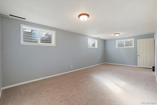 basement with light colored carpet and a textured ceiling