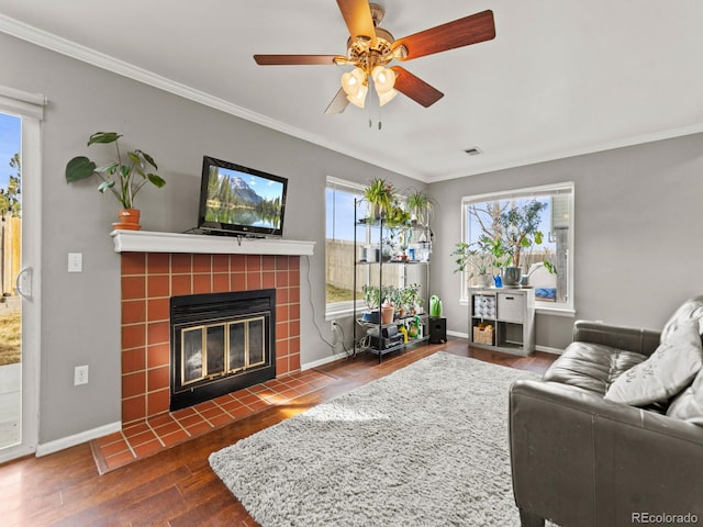 living room with baseboards, a fireplace, ornamental molding, and wood finished floors