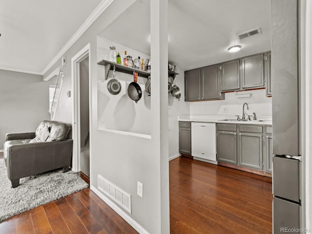 kitchen featuring crown molding, white dishwasher, visible vents, and a sink