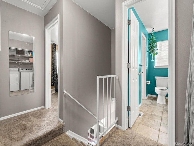 hall featuring baseboards, visible vents, carpet flooring, an upstairs landing, and separate washer and dryer