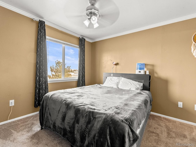 carpeted bedroom with ceiling fan, baseboards, and crown molding