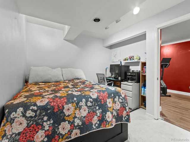 bedroom with light wood finished floors and baseboards