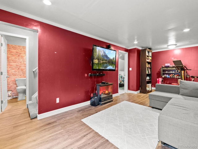 living room with stairs, an accent wall, ornamental molding, and wood finished floors