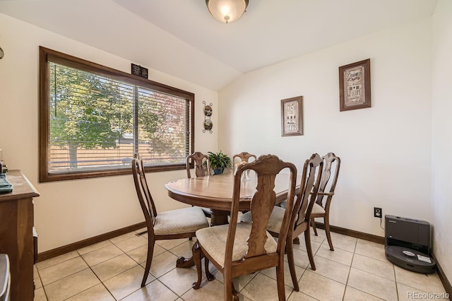 tiled dining room featuring lofted ceiling