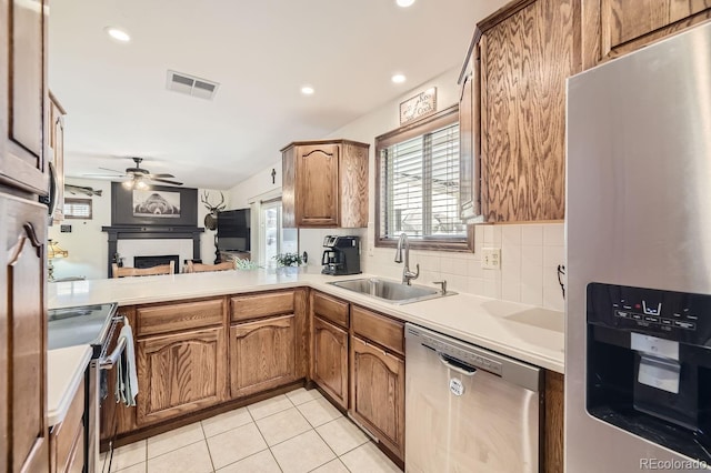 kitchen featuring kitchen peninsula, sink, light tile patterned floors, appliances with stainless steel finishes, and ceiling fan