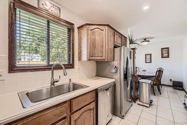 kitchen featuring tasteful backsplash, stainless steel appliances, sink, and light tile patterned floors