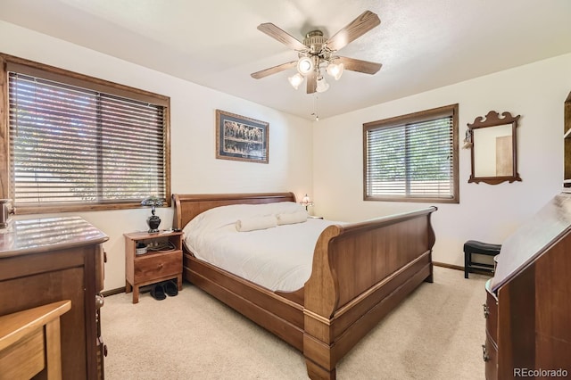 carpeted bedroom featuring ceiling fan and multiple windows