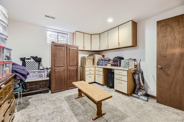 kitchen featuring cream cabinets and light colored carpet